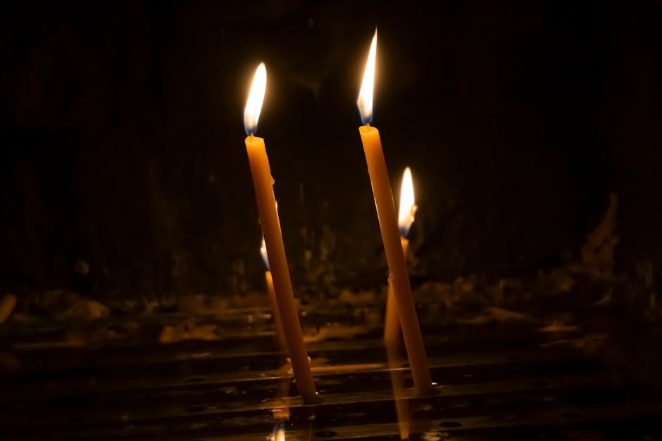 Llit candles in the dark representing enlightenment and clarity in our FAQ section